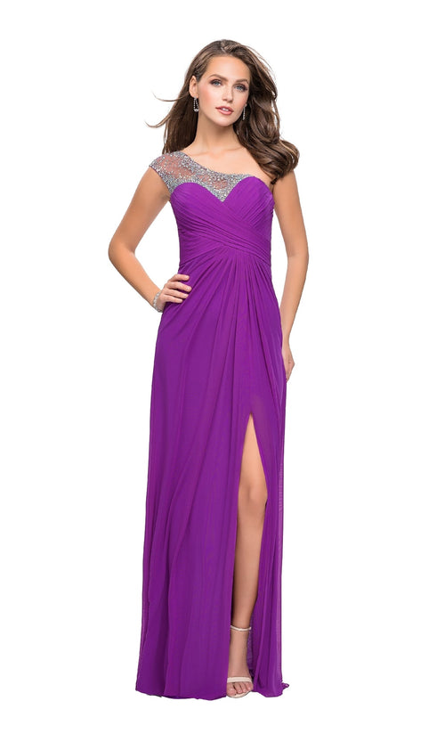 A woman in the La Femme 20384 one-shoulder long prom dressâ€”a purple floor-length gown with a jeweled neckline and thigh-high slitâ€”stands against a white background.