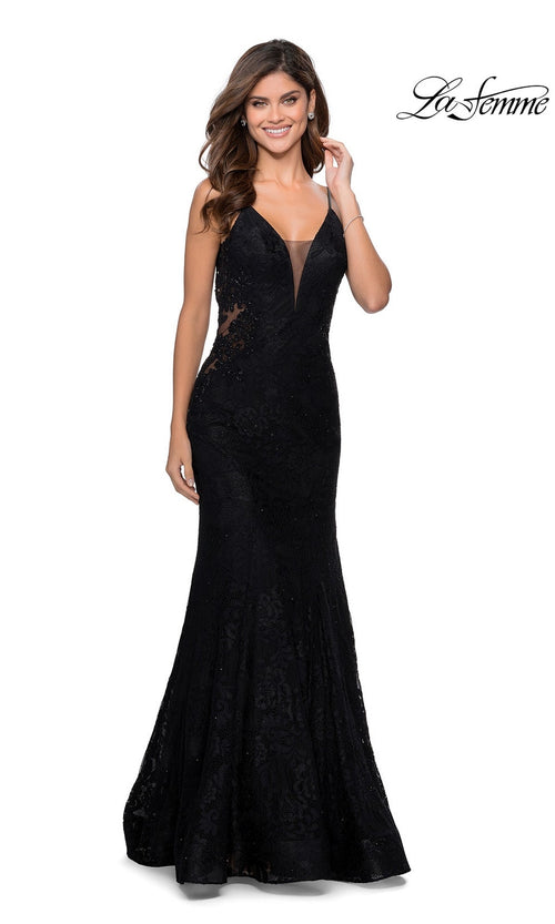 A woman smiles in the La Femme Backless Long Lace Prom Dress 28355, featuring a fitted black lace design with a plunging neckline, sheer side panels, and dramatic mermaid skirt, posed against a white background. The La Femme logo is in the top right corner.