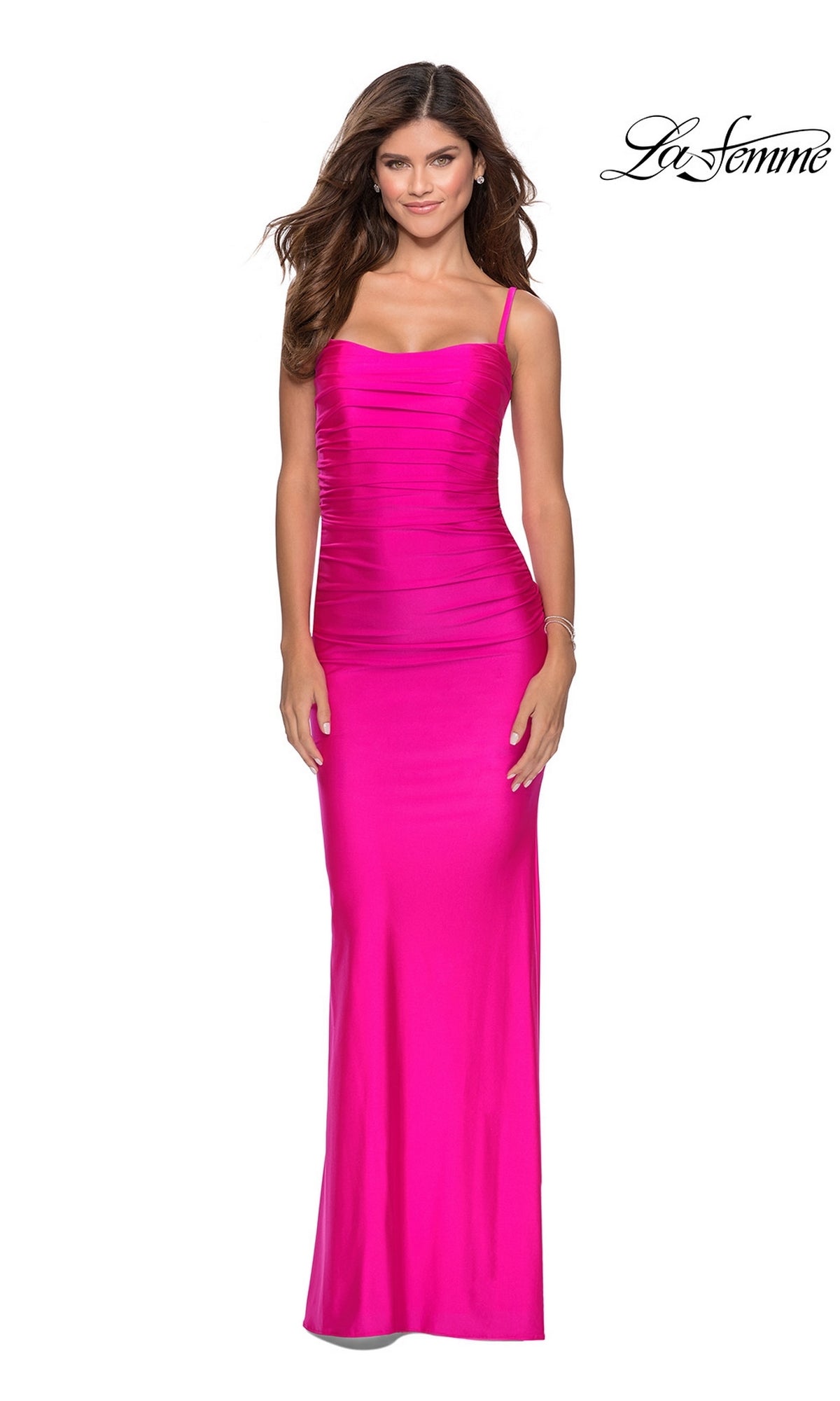 A woman models the La Femme Strappy-Back Long Tight Prom Dress 28398â€”bright pink, floor-length, sleeveless with thin straps and a ruched silhouetteâ€”against a white background. The La Femme logo is displayed in the top right corner.