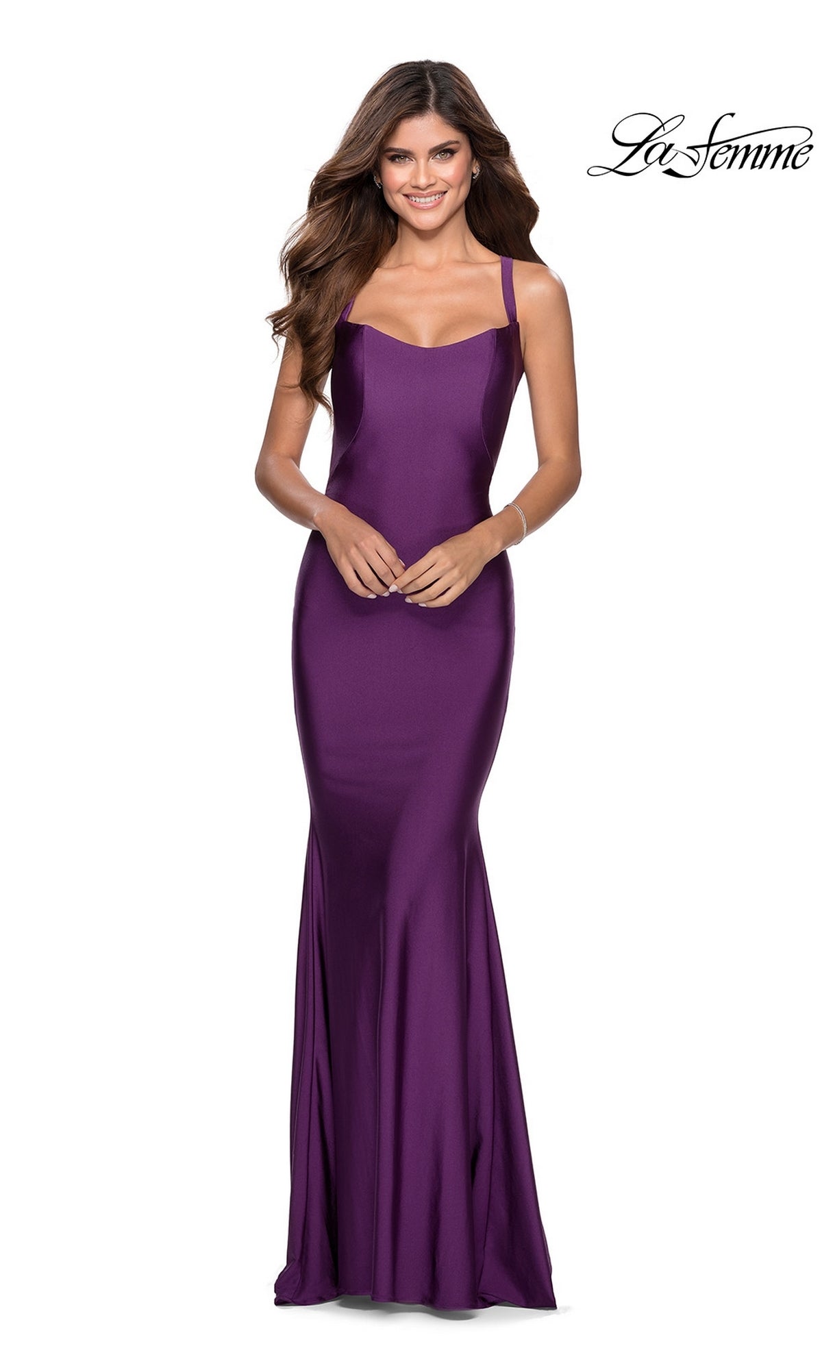 Smiling woman in a floor-length, sleeveless purple La Femme Simple Long Prom Dress 28568 with thin straps and open back, set against a white background. "La Femme" logo appears in the top right cornerâ€”ideal for formal events.