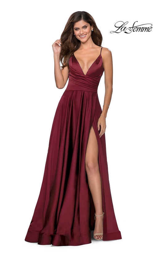 A woman wearing a sleeveless La Femme V-Neck Long A-Line Prom Dress 28607 with a high slit, standing and smiling.