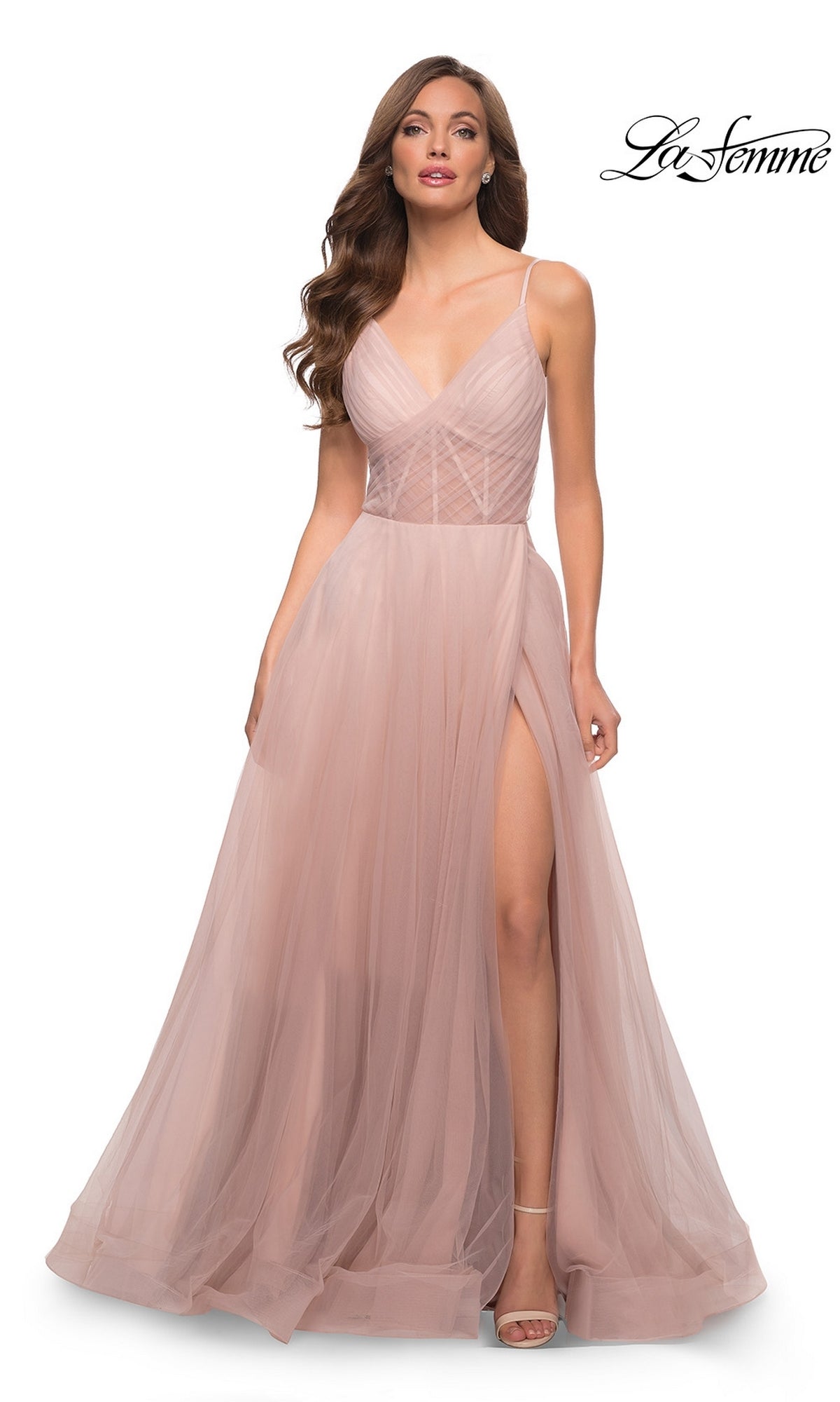 A woman wears the La Femme Sheer-Waist Long A-Line Prom Dress 29076 in dusty mauve, featuring spaghetti straps, a fitted bodice, a high leg slit, and a floor-length skirt; "La Femme" logo appears in the top right corner.