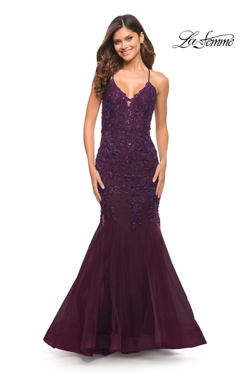 A woman in a sleeveless, dark berry Backless Long Lace Mermaid Prom Dress by La Femme with sequin accents stands smiling, facing forward. The "La Femme" logo is displayed in the top right corner.