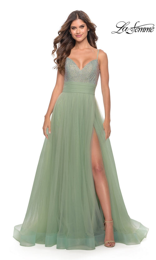 Woman wearing Beaded-Bodice Tulle Prom Ball Gown 31238 with a sleeveless light green beaded bodice, tulle skirt, and thigh-high slit. She stands smiling, with the La Femme logo in the top right corner.