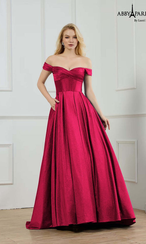 A woman wearing the Abby Paris 90373 Long Prom Dress in wine stands in a white-paneled room.